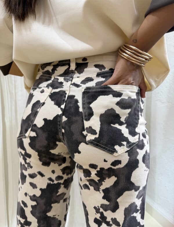 COMPRAR Pantalón de tejido denim con estampado animal negro sobre crudo, tiro medio y pierna recta. Bolsillos de cinco bolsillos y cierre clásico.