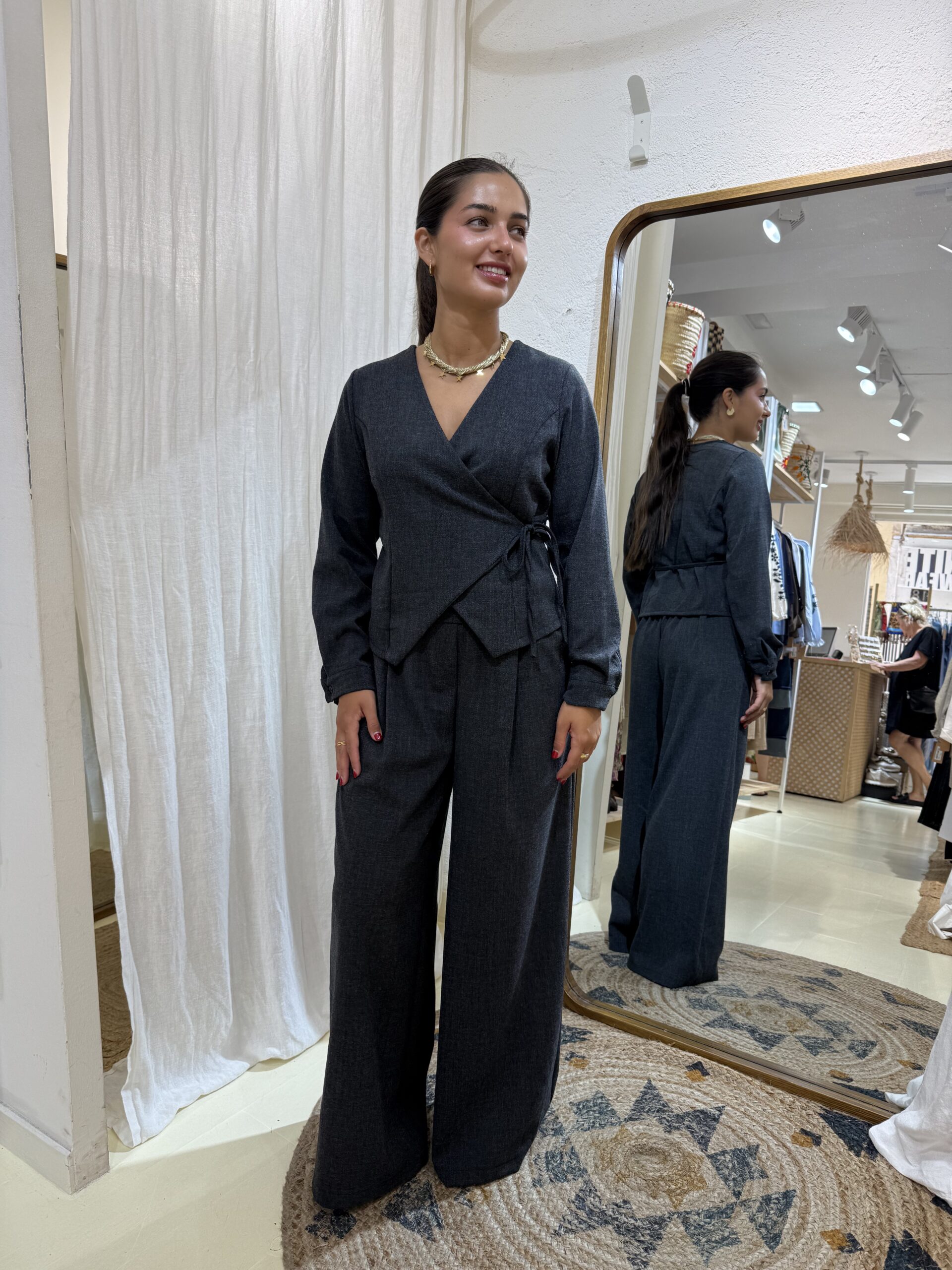 COMPRAR Conjunto de tejido tipo sastre con top cruzado de lazo lateral y pantalón wide leg de tiro alto con pinzas. Disponible en gris antracita y beige.